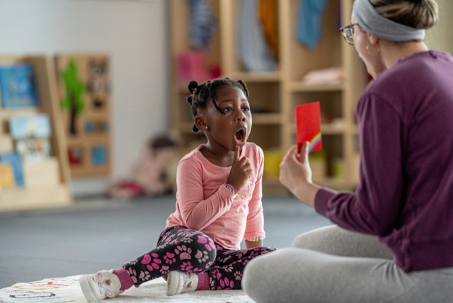 A parent reading a picture book with a young child.