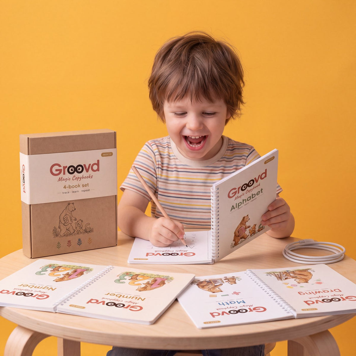 A boy laughing while he writes in a Groovd copybook