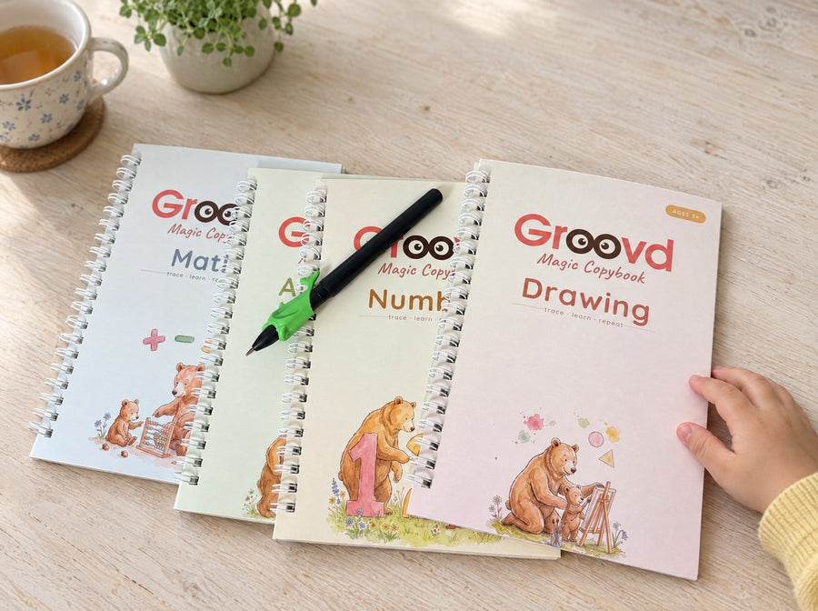 The four Groovd copybooks laid flat with the magic pen and green dolphin grip