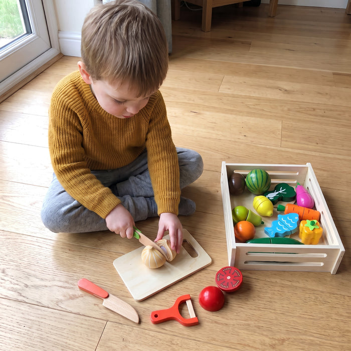 A child playing with the Fruit and Veggie Cutting Set