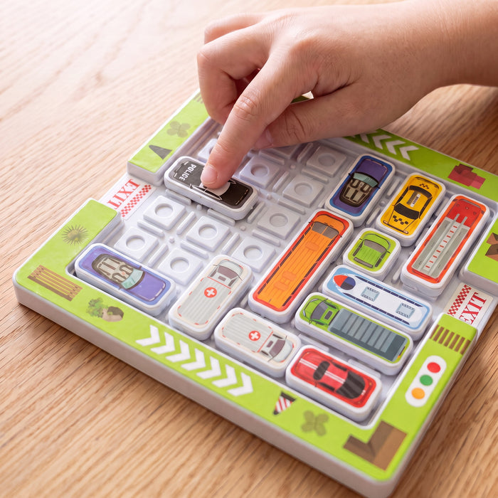 A hand slides the police car tile along the board, between a bus, two ambulances, a fire truck and other cars