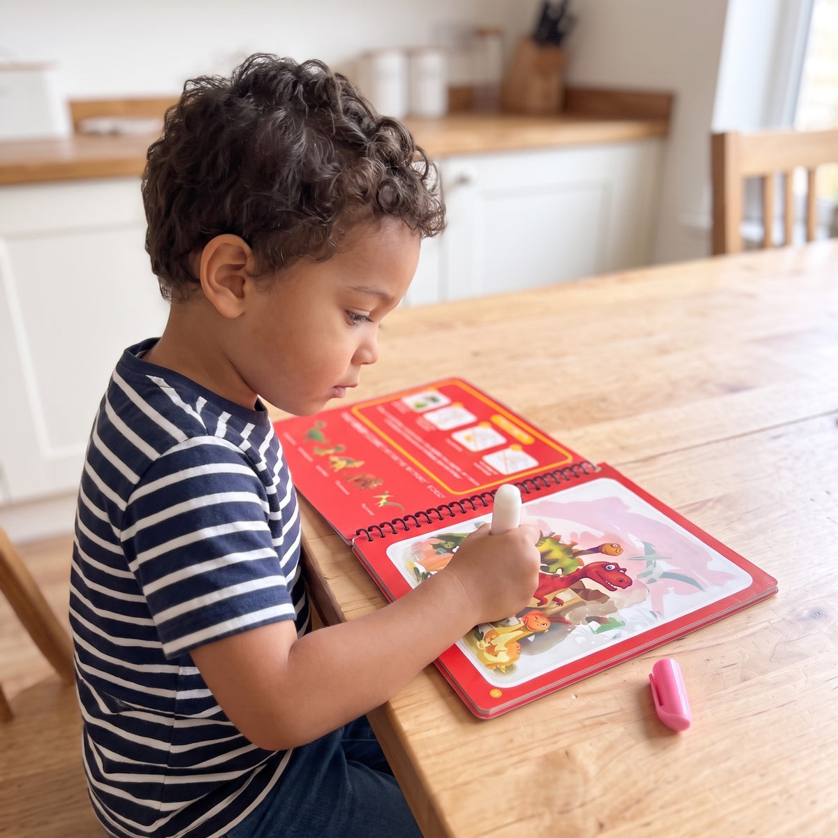 A child playing with the Magical Water Drawing Book